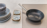 Wave inductiekookplaat met een pan en schalen erop voor modern koken